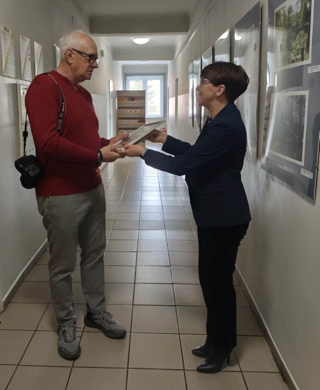 osoby przed regałami z książkami