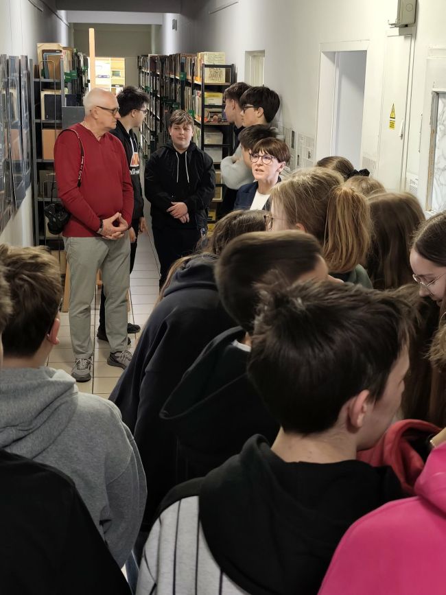 osoby zgromadzone na korytarzu, oglądajace wystawę zdjeć