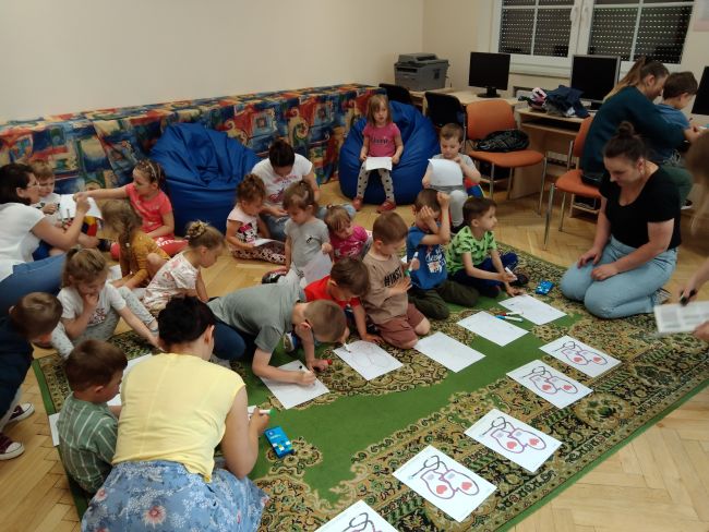 Na zdjęciu dzieci z przedszkola z opiekunkami podczas zajęć