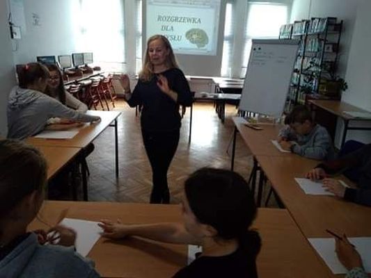 Zdjęcie przedstawia kobietę prowadzącą warsztaty dla młodzieży